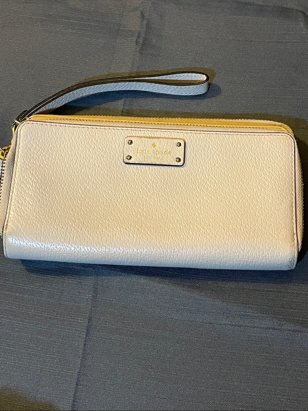 kate spade cream pebbled leather wristlet clutch with gold-tone plaque